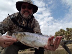man holding shad caught on fly rod