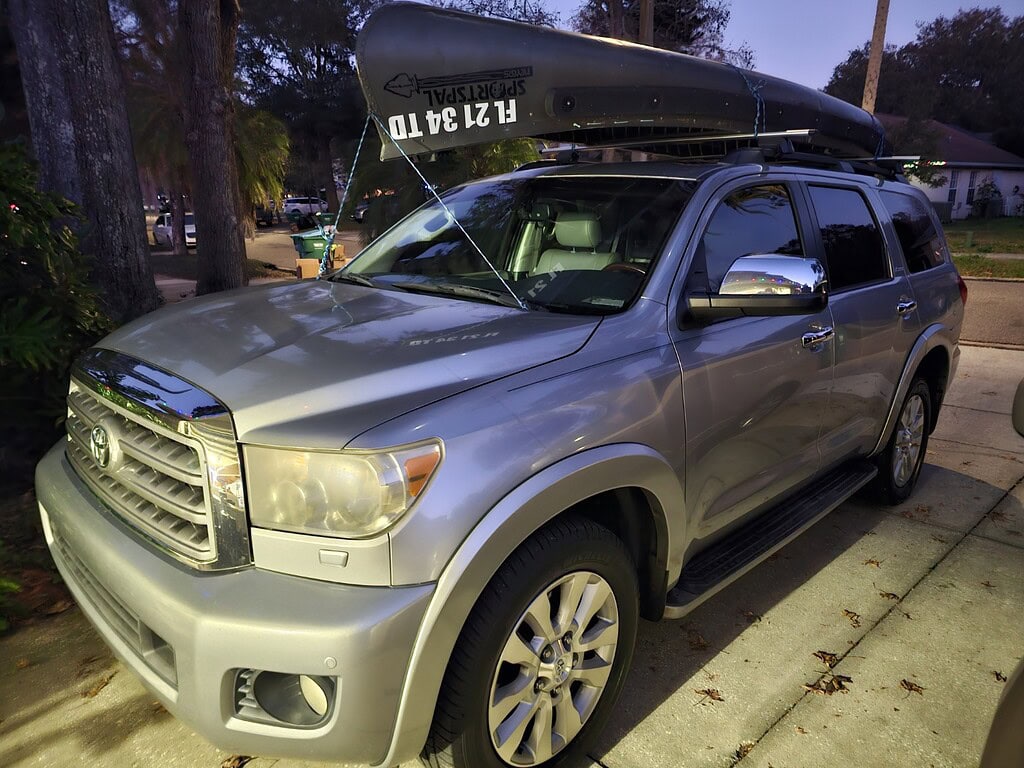 Canoe on top of a silver SUV ready for fly fishing adventures.