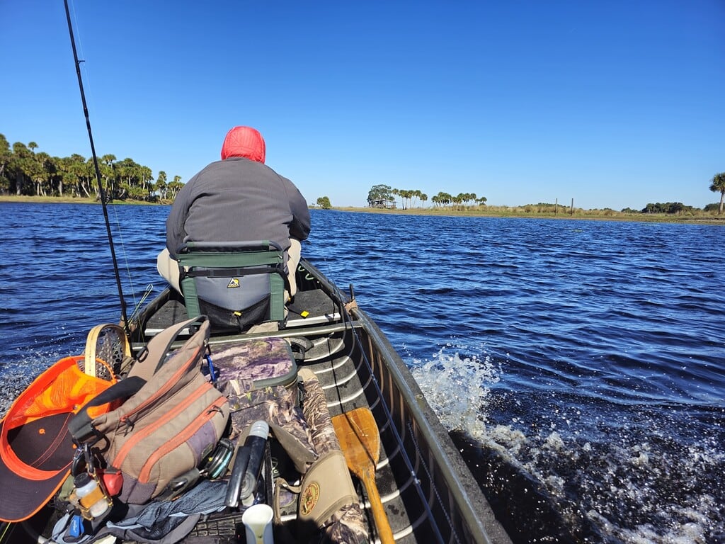 A person is sitting in a fishing boat, ready for American and Hickory Shad fly fishing.